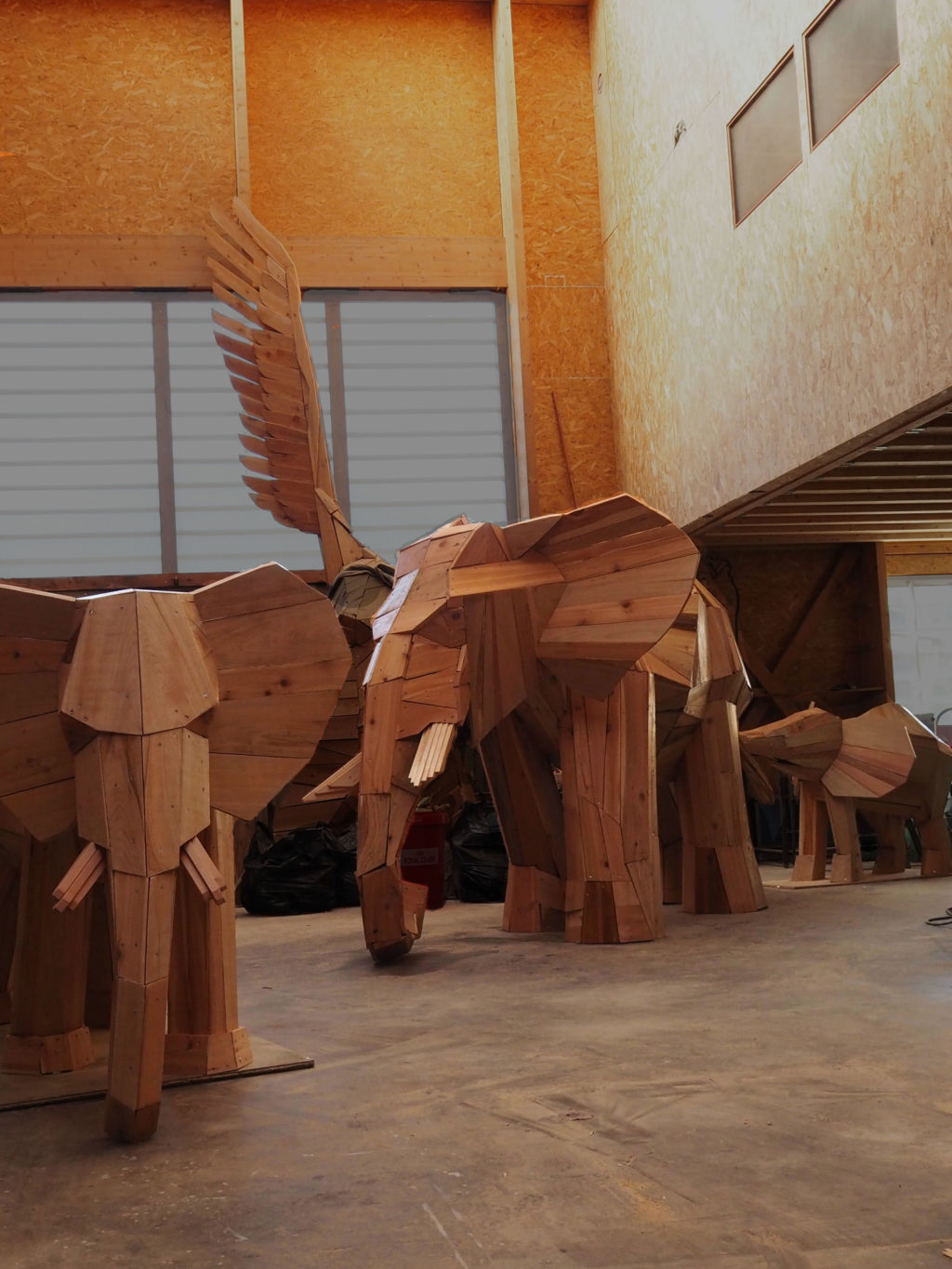 Photo d'une sculpture dans l'atelier de l'artiste Christian Burger représentant des éléphants en bois, créés et réalisées pour le Lobby du Club Med de La Rosière en Savoie Mont Blanc, France.